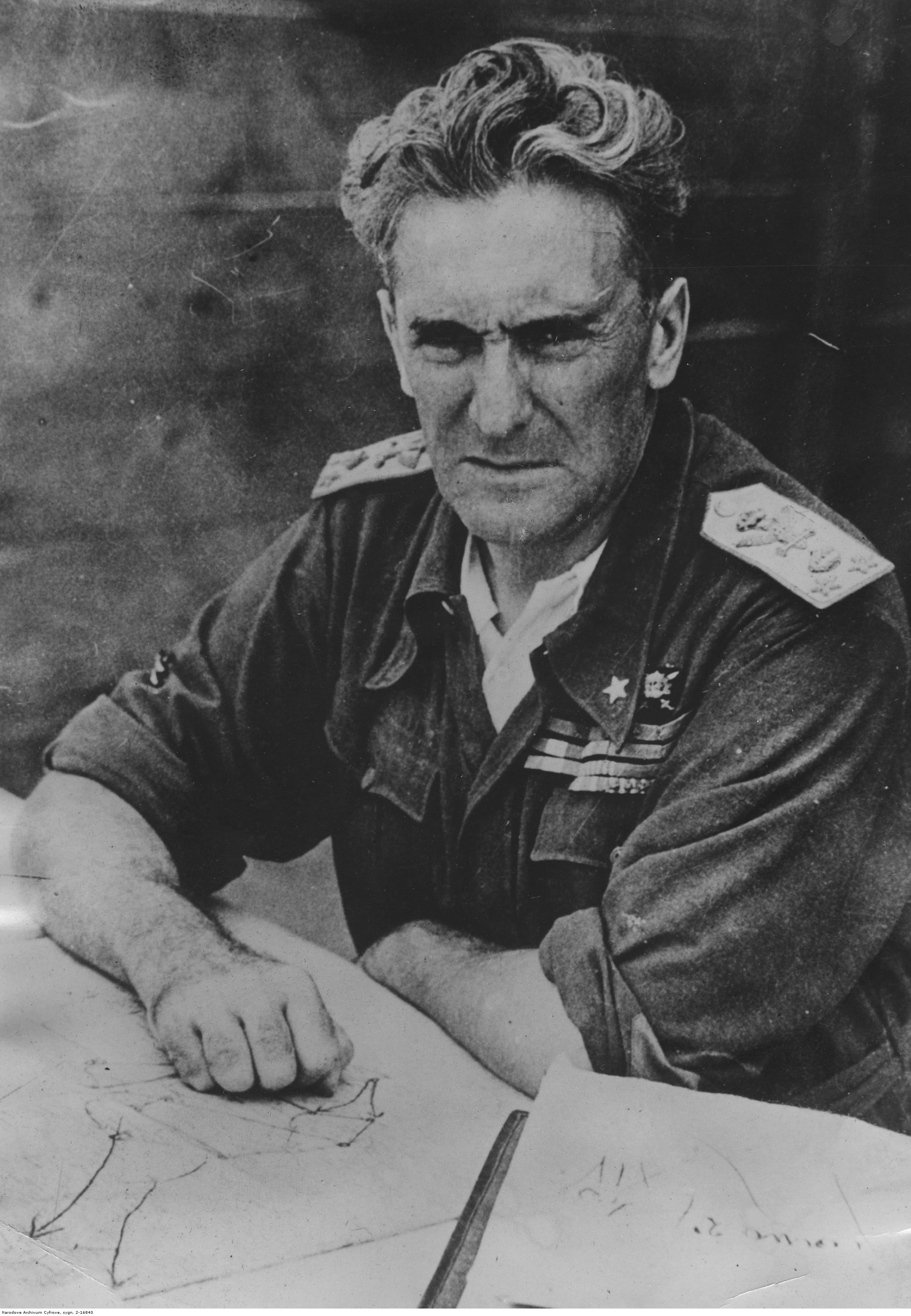 A black and white portrait photo of General Graziani. He is sitting at a desk looking directly into the camera, looking fairly disheveled, wearing a military uniform.